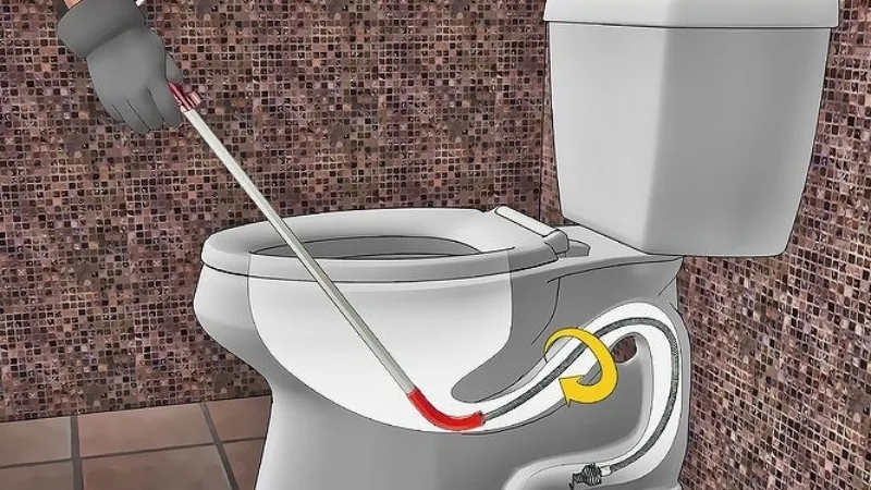 Xử lý bồn cầu bị nghẹt bằng dụng cụ khoan dây cáp lò xo (thông tắc cống)